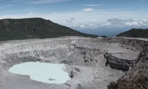 A large volcanic crater lake surrounded by rugged, barren slopes.